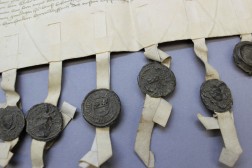 Detailaufnahme einer Pergamenturkunde mit Plica, Siegelschnüren aus Pergament und Wachsiegeln