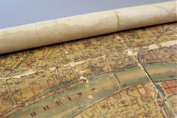 Detailaufnahme einer gerollten Schulkarte mit Abbildung der Stadt Köln, partiell hebt sich das Papier vom Gewebeträger ab
