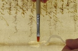 Blatt einer Urkunde, ein Riß wird mit Pinsel, Kleister und Japanpapier geschlossen